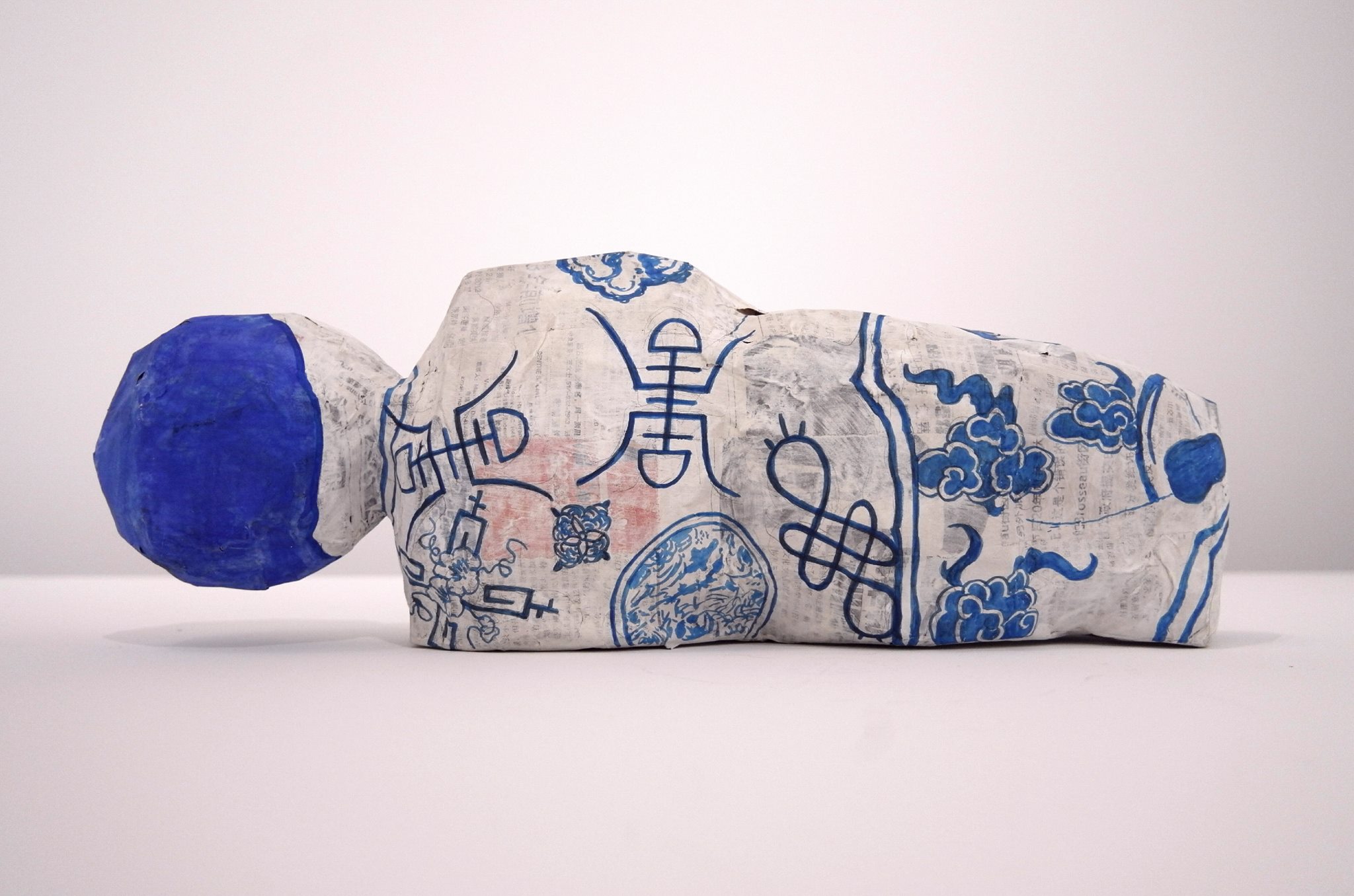 Karen Tam, <em>Sleeping Figure No. 1</em>, 2016. Papier mâché (journal chinois, colle à papier peint), carton, gesso, gouache, encre de Chine, 16,5 x 46,35 x 12 cm. © Karen Tam